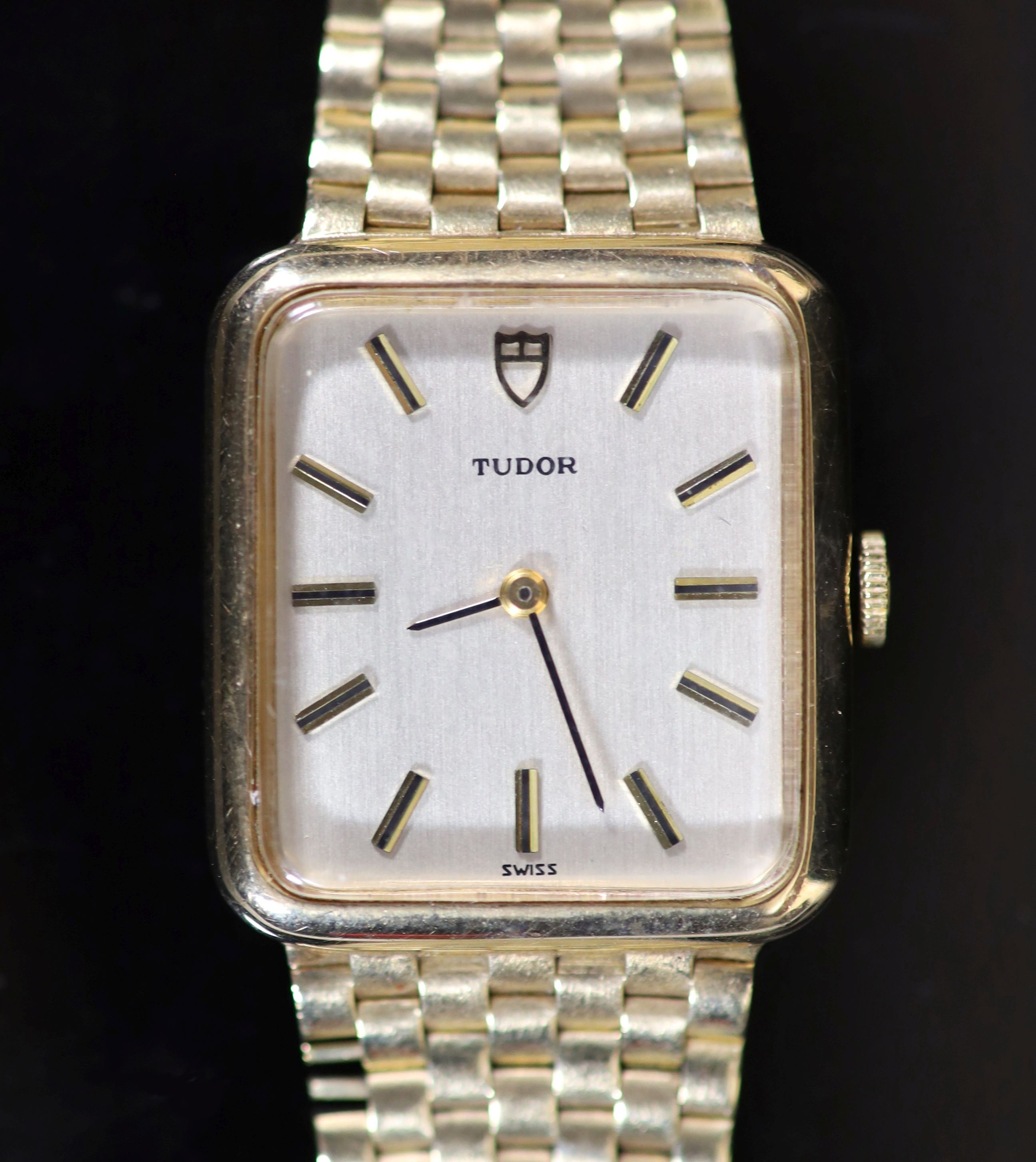 A lady's 1980's 9ct gold Tudor manual wind rectangular dial wrist watch, on an integral 9ct gold brick link bracelet